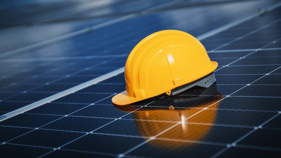 Hard hat resting on a solar panel array